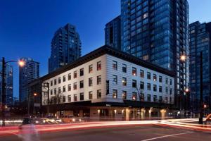 a building on a city street with tall buildings at Moda Hotel in Vancouver