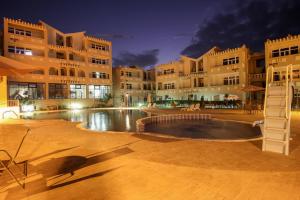 een groot gebouw met een zwembad ervoor bij Complexe Touristique BouZour in Mostaganem