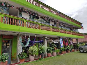 a green building with a balcony and potted plants at Residencial El Valle in Valle de Anton