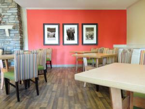 a restaurant with tables and chairs and a red wall at Extended Stay America Suites - Fairbanks - Old Airport Way in Fairbanks
