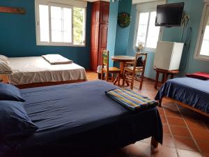 a room with two beds and a tv and a table at Residencial El Valle in Valle de Anton