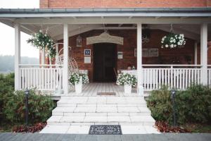 a front porch of a brick building with flowers at Villa Spełnione Marzenia in Okuninka