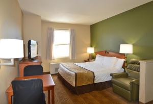 a hotel room with a bed and a chair at Extended Stay America Suites - Fairbanks - Old Airport Way in Fairbanks
