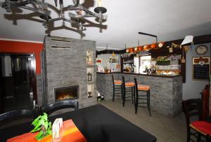 a restaurant with a fireplace and a bar with stools at Penzion SATY in Liptovské Sliače