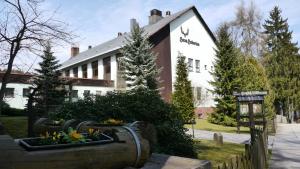 a building with a flower garden in front of it at Naturparkhotel Haus Hubertus in Oybin