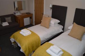 ein Zimmer mit 2 Betten und Handtüchern darauf in der Unterkunft Air Leth Bed & Breakfast in Portree