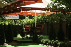 a table and chairs under an umbrella in a garden at ABBA Hotel in Kyiv