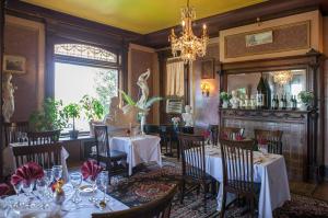 a dining room with tables and chairs and a chandelier at Henderson Castle Inn in Kalamazoo