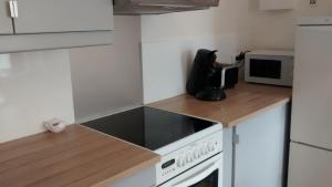 a kitchen with white cabinets and a stove top oven at Le Petit Mansart in Versailles +18 photos
