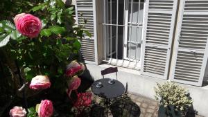 a balcony with a chair and flowers in front of a window at Le Petit Mansart in Versailles