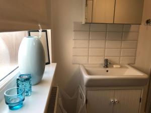 a bathroom with a sink and a vase on a counter at BEAUTIFUL HOME, 3 BEDROOM HOUSE near Alton Towers, Wedgwood museum, Universities in Newcastle under Lyme