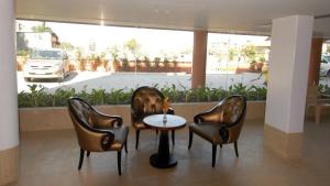 a lobby with three chairs and a table and a car at Sai Palace Budget Hotel in Shirdi