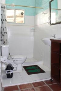 a bathroom with a toilet and a sink at Descanso en el Campo in Cali