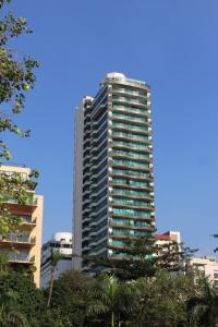 ein hohes Gebäude mit Bäumen davor in der Unterkunft Baywatch Tower in Manila