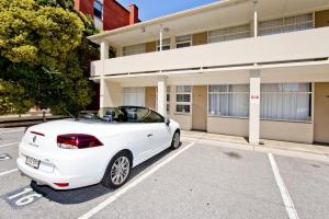 a white car parked in front of a building at Glenelg Oasis Studios in Adelaide