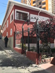 a man walking in front of a red building at Anami Hotel Boutique in La Paz