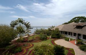 a house with a garden and a bridge in the background at Hôtel Kadiandoumagne in Ziguinchor