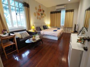 a living room with a bed and a couch at The Serene House Bangkok in Bangkok