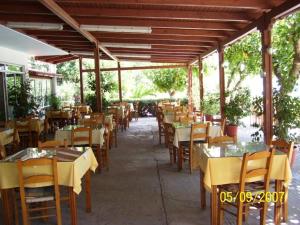 a restaurant with tables and chairs with yellow table cloth at Nikos & Anna Rooms in Rodakino