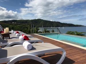 a row of lounge chairs next to a swimming pool at Hotel La Gaviota Tropical in Playa Hermosa