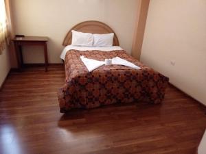 una camera d'albergo con un letto e due asciugamani di Hostal Intiwatana Inn a Puno