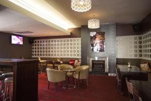 a restaurant with a fireplace and tables and chairs at Nags Head Hotel in Newcastle