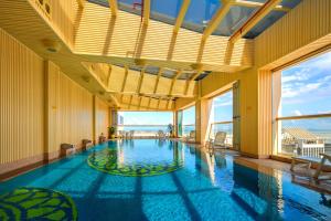 澳門的住宿－利澳酒店，一座大型游泳池,位于一座带窗户的建筑内