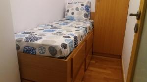 een kleine slaapkamer met een bed met een houten frame bij Matosinhos Relax and Fun by PortoProperties4You in Matosinhos