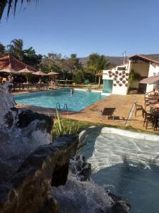a swimming pool with a waterfall in a resort at Village da Serra in Serra do Cipo