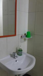 een witte wastafel in een badkamer met een spiegel bij Robert's Callia at East Jakarta in Jakarta