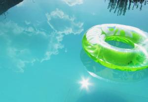 a green and white lifebuoy in a swimming pool at Гостевой дом Chimgan Apple Garden in Chimgan