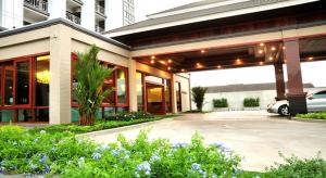 a building with a car parked in a parking lot at Green Hill Hotel Phayao in Phayao