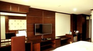 a bedroom with a desk with a tv and a bed at Green Hill Hotel Phayao in Phayao