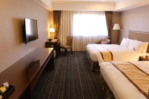Fushin Hotel - Tainan tesisinde bir odada yatak veya yataklar