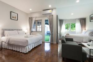 Un dormitorio con dos camas y una sala de estar. en Cozy Home by Nan, en Chiang Mai