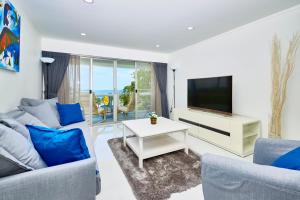 a living room with a couch and a tv at LUXURIOUS APARTMENT on JOMTIEN BEACH ROAD in Jomtien Beach +25 photos