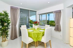 a dining room with a table and white chairs at LUXURIOUS APARTMENT on JOMTIEN BEACH ROAD in Jomtien Beach