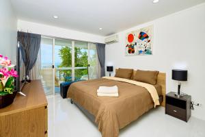 a bedroom with a bed and a large window at LUXURIOUS APARTMENT on JOMTIEN BEACH ROAD in Jomtien Beach