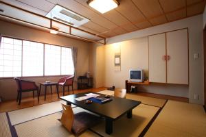 Takinoya Bekkan Tamanoyu في نوبوريبيتسو: غرفة معيشة مع طاولة وغرفة طعام