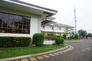 a white building with a lot of windows and bushes at Lugano Bed and Breakfast in Santa Ana