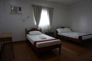 um quarto com 2 camas e uma janela em Lugano Bed and Breakfast em Santa Ana