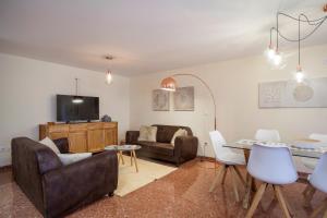 バレンシアにあるJardines del Turia - Espacioso apartamentoのリビングルーム(ソファ、テーブル、椅子付)