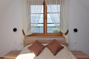 sypialnia z łóżkiem i dużym oknem w obiekcie Prie Žiedo w mieście Troki