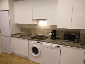 a kitchen with white cabinets and a washing machine at Apartamento espacioso frente al Palacio de Congresos - AA in Salamanca