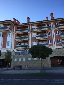 a large building with a bench in front of it at Apartamento Costa con Parking Privado Incluido in Zumaia