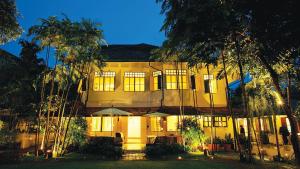 a large yellow building with trees in front of it at Baan mek mok in Bangkok