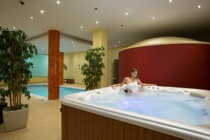 a woman sitting in a hot tub in a hotel at Porto Galini Seaside Resort & Spa in Nikiana