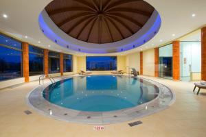 a large pool in a hotel with a large ceiling at Porto Galini Seaside Resort & Spa in Nikiana