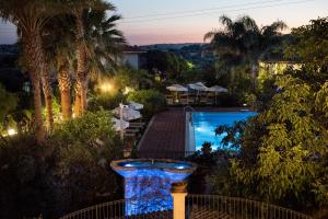 uitzicht op een zwembad vanuit een resort 's nachts bij Agriturismo Il Granaio Hotel & SPA in Modica