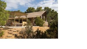 una casa su una collina con alberi sullo sfondo di Tente Lodge Bord de Mer a Coti-Chiavari Altre 17 foto